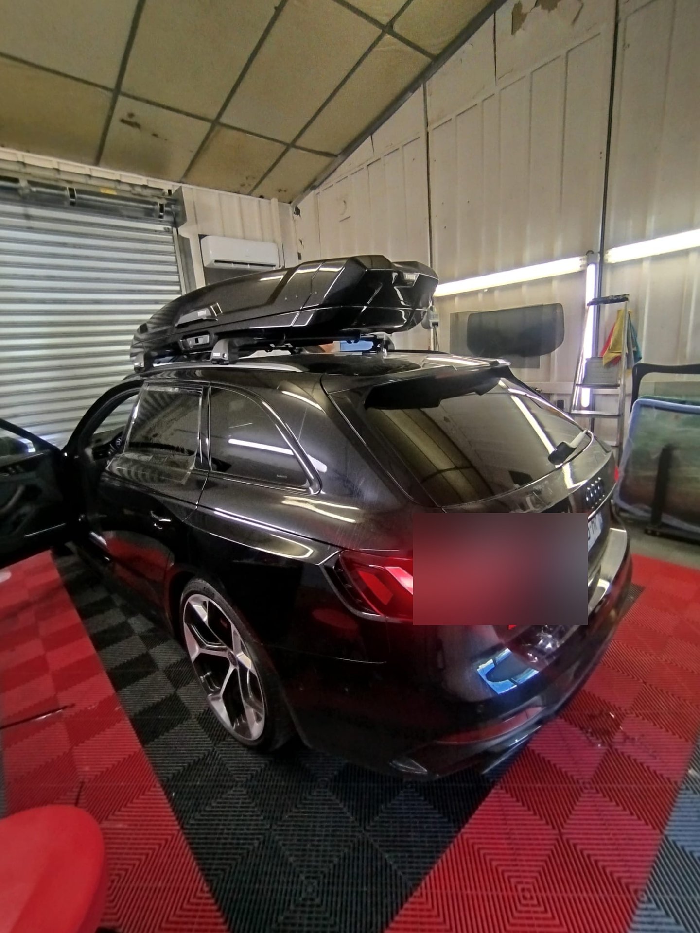 Audi RS4 Avant noire avec coffre de toit et vitres teintées