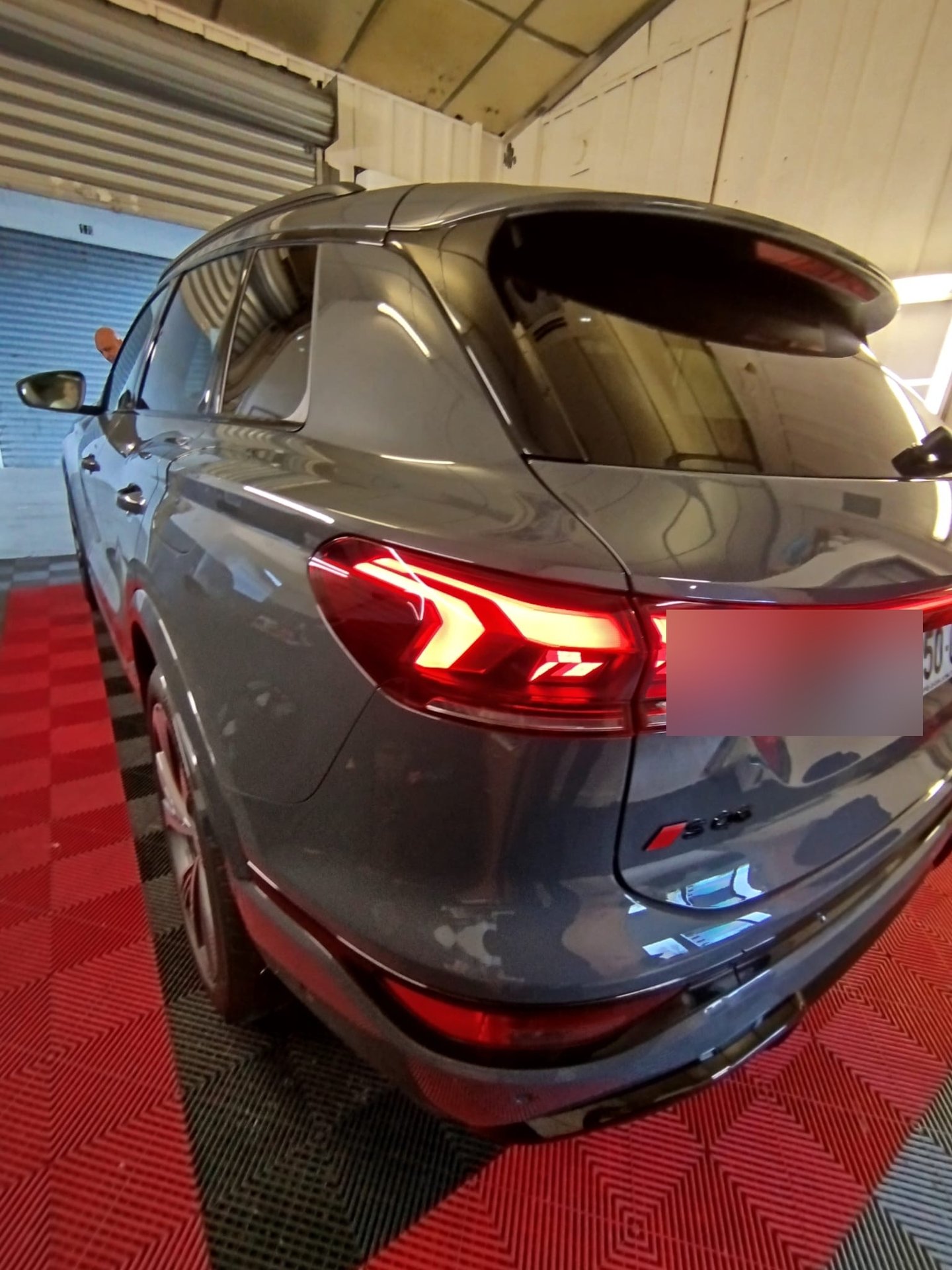 Audi SQ8 gris Daytona avec vitres teintées, feux LED allumés