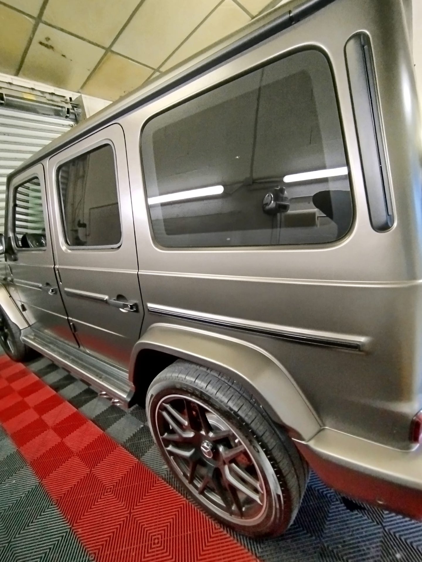 Mercedes Classe G gris clair avec vitres teintées dans l'atelier